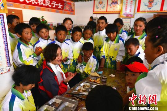 高敏与山南市重点业余体校体的孩子们一起吃午饭，孩子们争先恐后提问、合影。　江飞波 摄