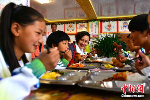 “星能冠军助学项目西藏行”活动由北京星能公益基金会主办，组织8位知名运动员进藏，计划对当地学习体育的孩子进行专业指导、扶助等。图为6月20日，中国知名运动员、两届奥运会跳水冠军高敏和西藏山南市重点业余体校的孩子们一起午餐。 江飞波 摄