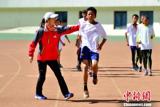 奥运竞走冠军王丽萍指导小运动员进行热身动作。　江飞波 摄