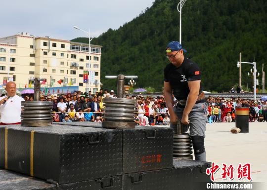 图为选手王琪正在进行提重物比赛。　高展 摄